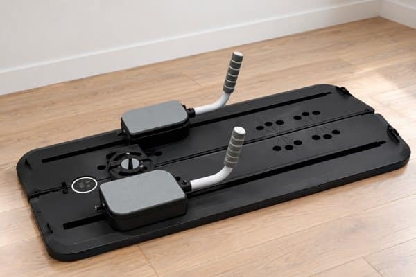 Zwart FitFirst Pilates board op een houten vloer